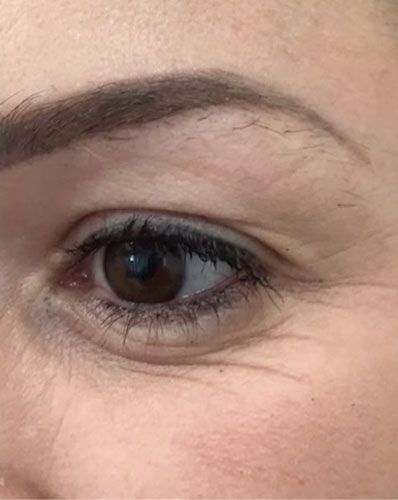Close-up of a brown eye with a dark eyebrow and visible fine lines on the skin