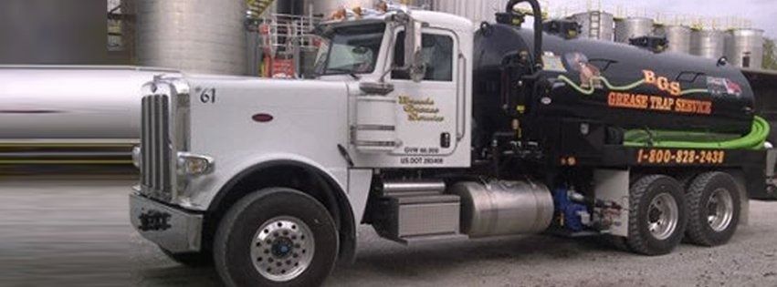 White septic truck with black tank, “Grease Trap Buster” logo, and phone number.