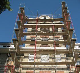 a large building is being remodeled with scaffolding around it .