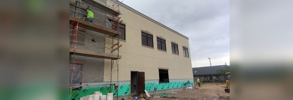 a man is standing on a scaffolding on the side of a building .