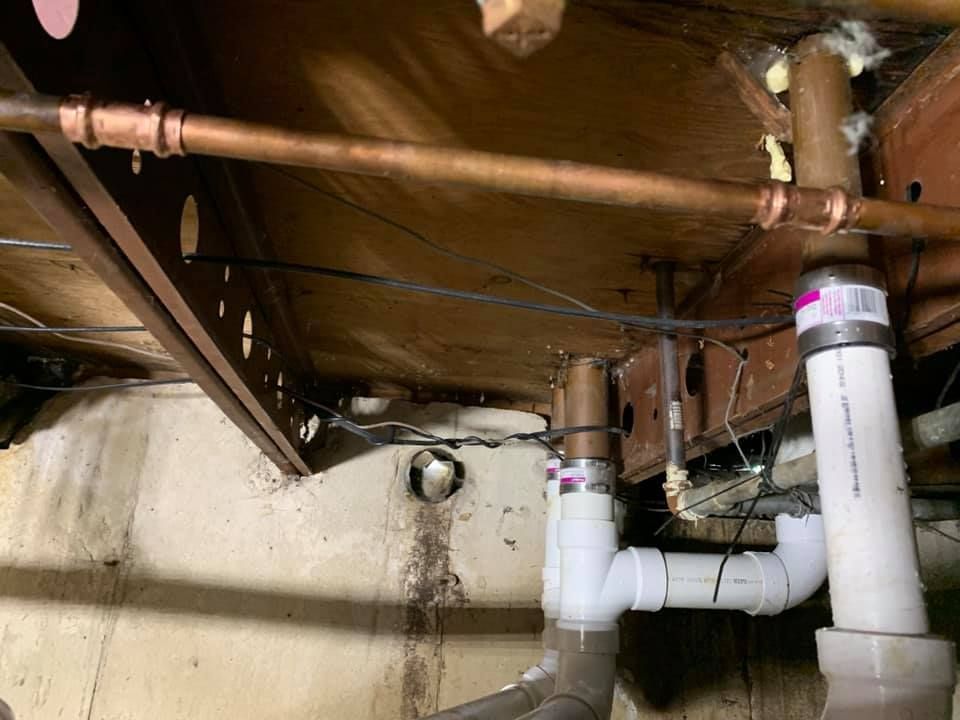 A bunch of pipes are hanging from the ceiling of a room.