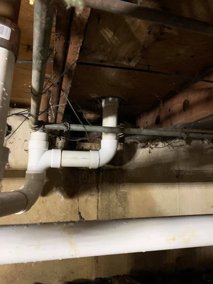 A bunch of pipes are hanging from the ceiling of a building.