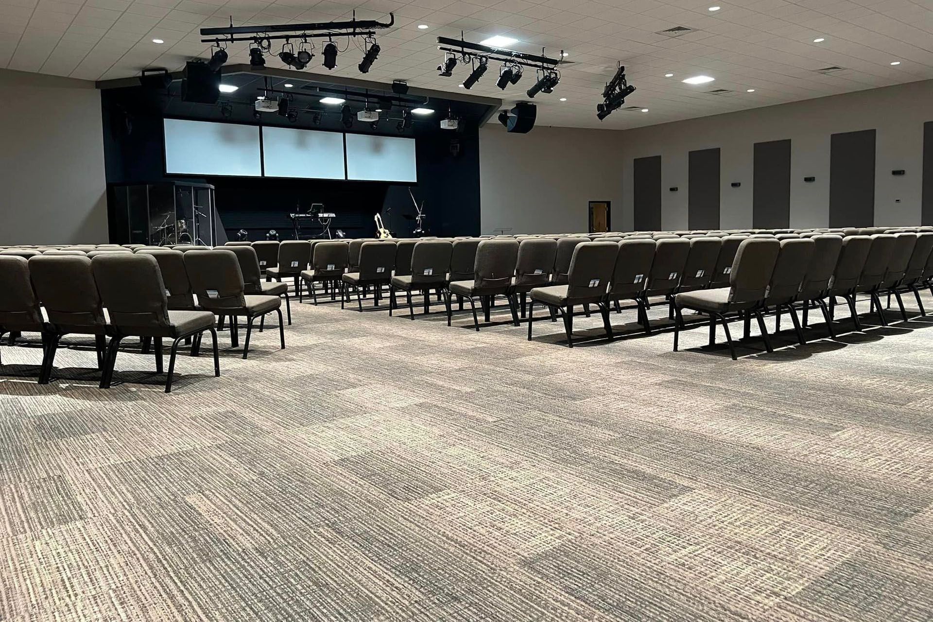 A large auditorium with rows of chairs and a stage