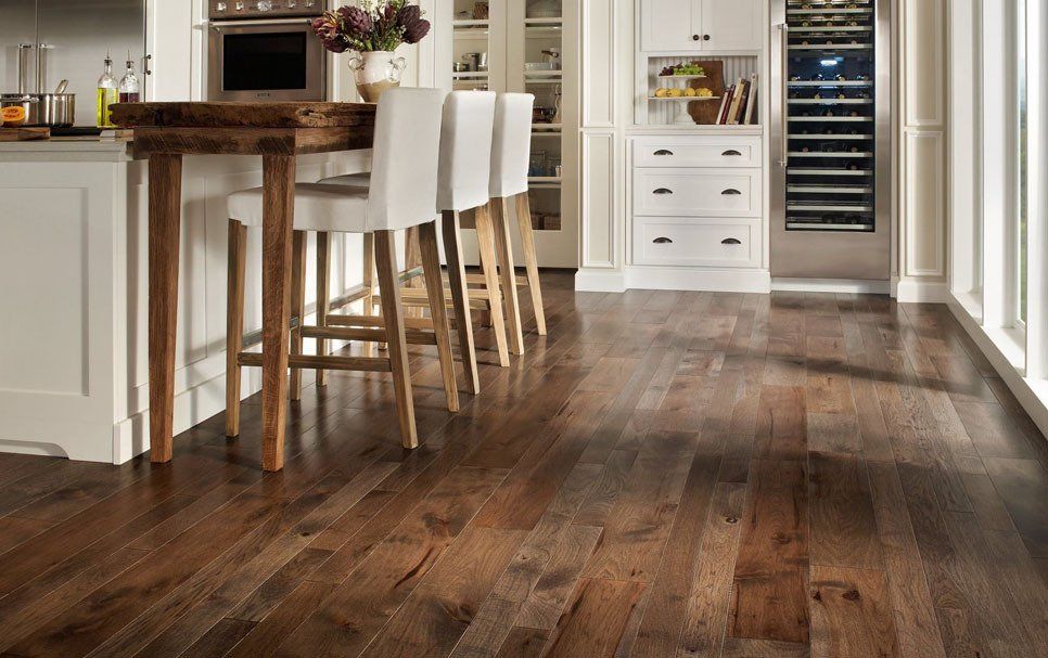 A kitchen with hardwood floors and white cabinets.
