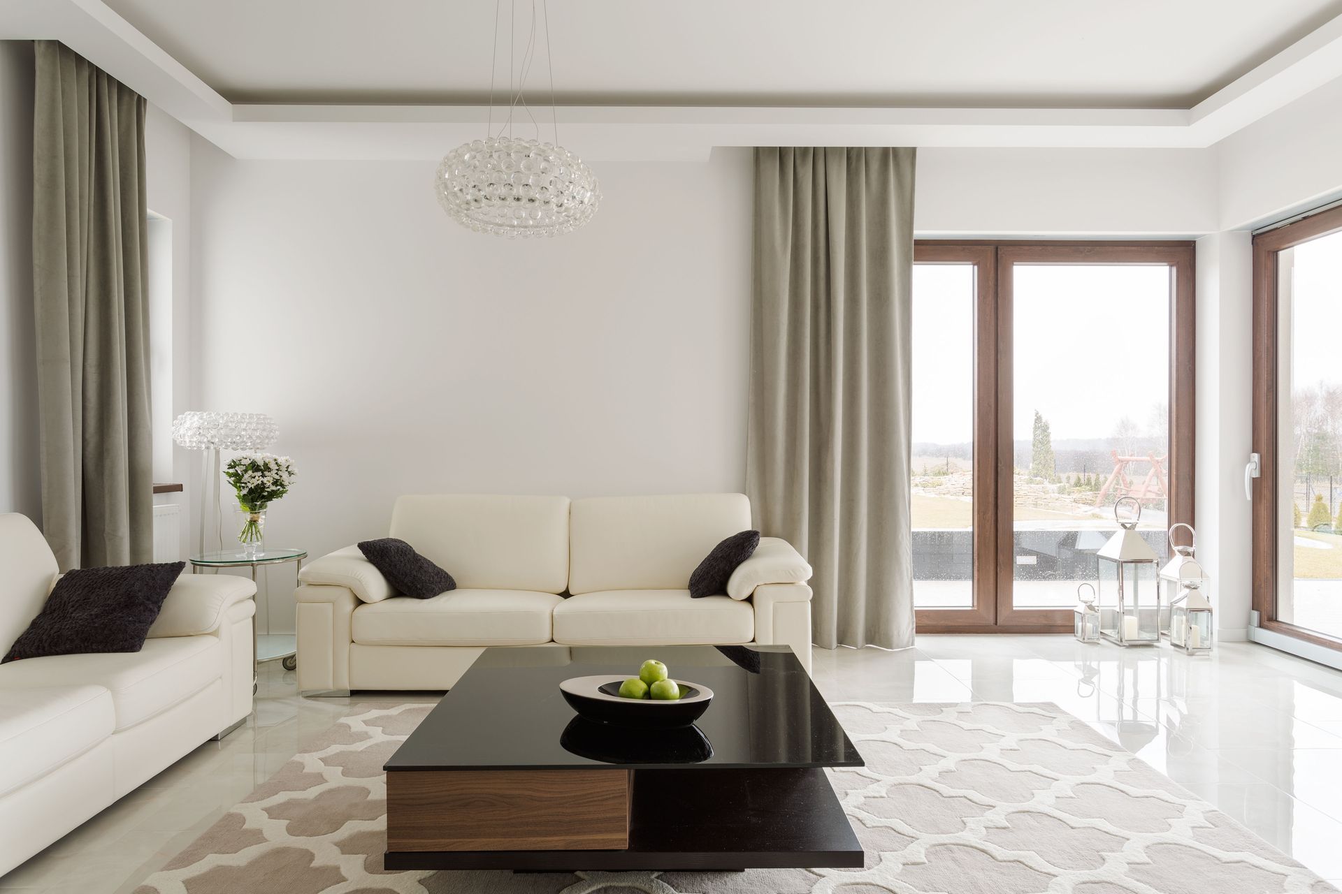 A living room with white furniture and a black coffee table.