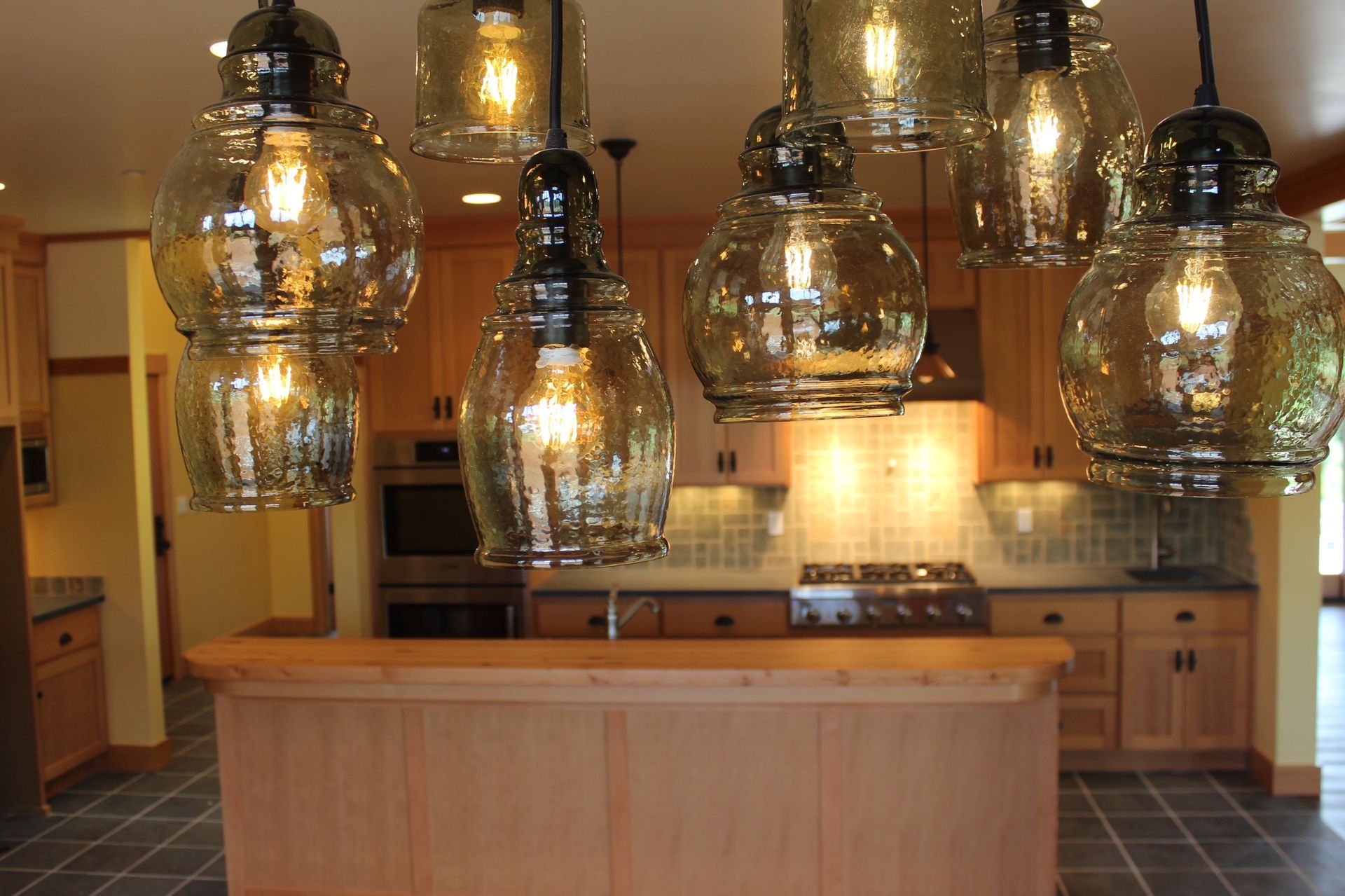 A kitchen with lots of lights hanging from the ceiling