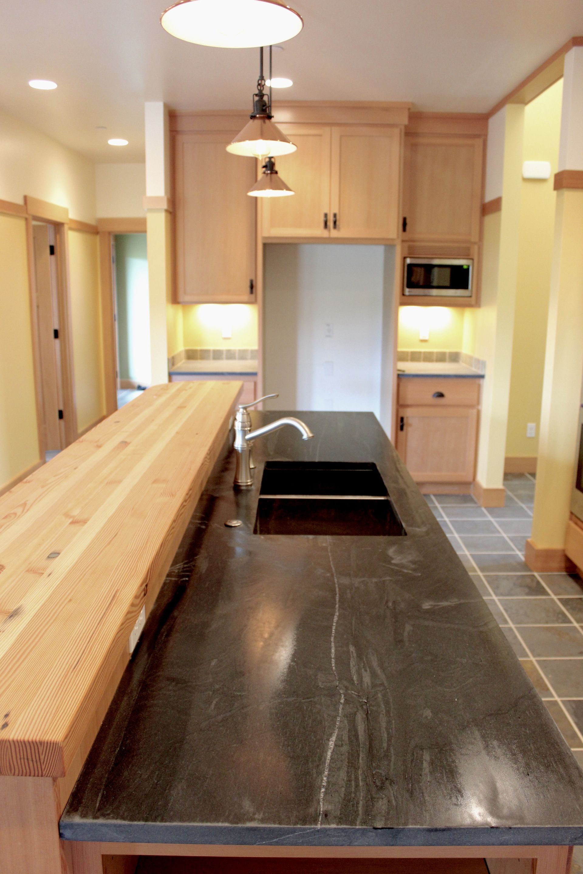 A kitchen with two sinks and a wooden counter top