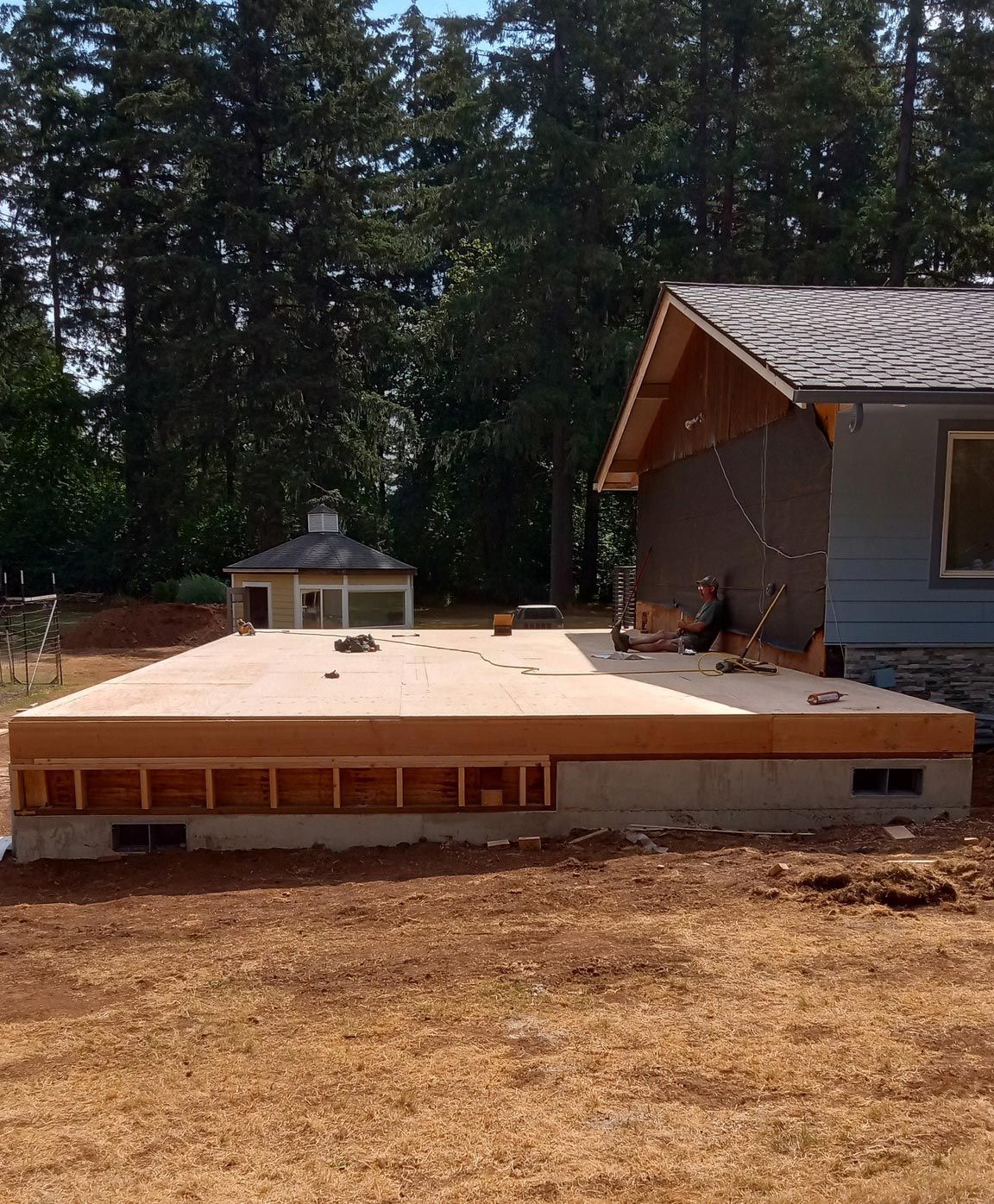 A house is being built in the middle of a dirt field