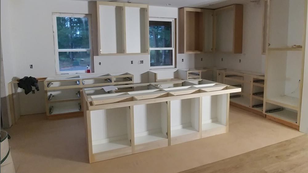 A kitchen under construction with a lot of cabinets and a sink.