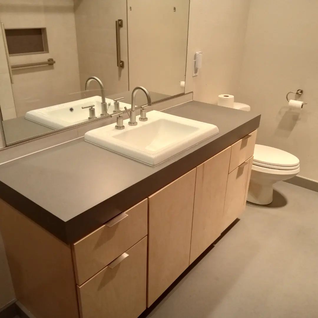 A bathroom with two sinks and a toilet