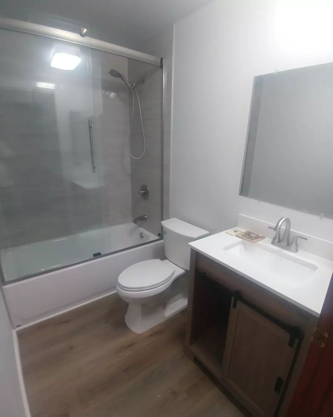 A bathroom with a toilet, sink, bathtub and shower