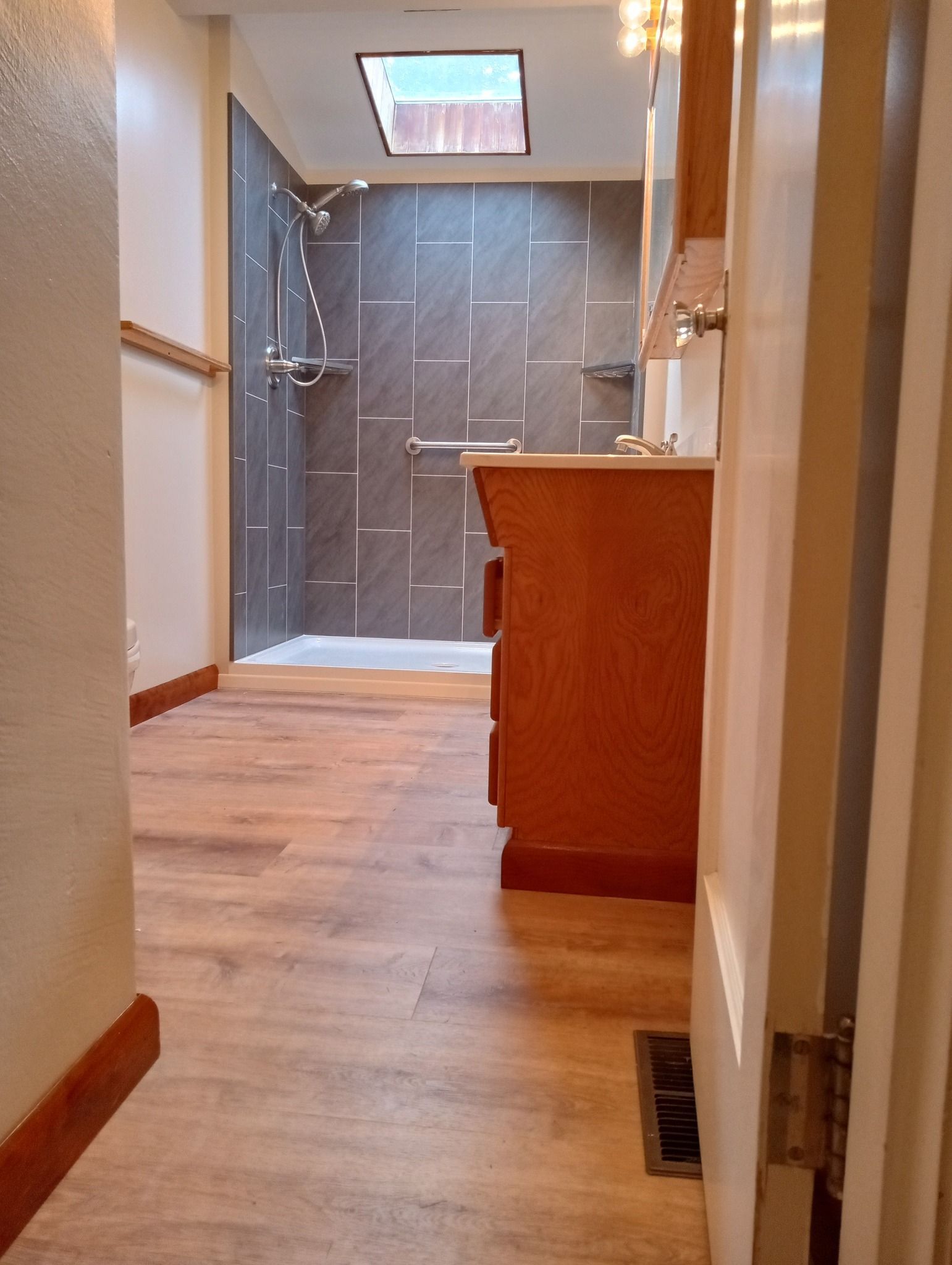 A bathroom with hardwood floors and a walk in shower