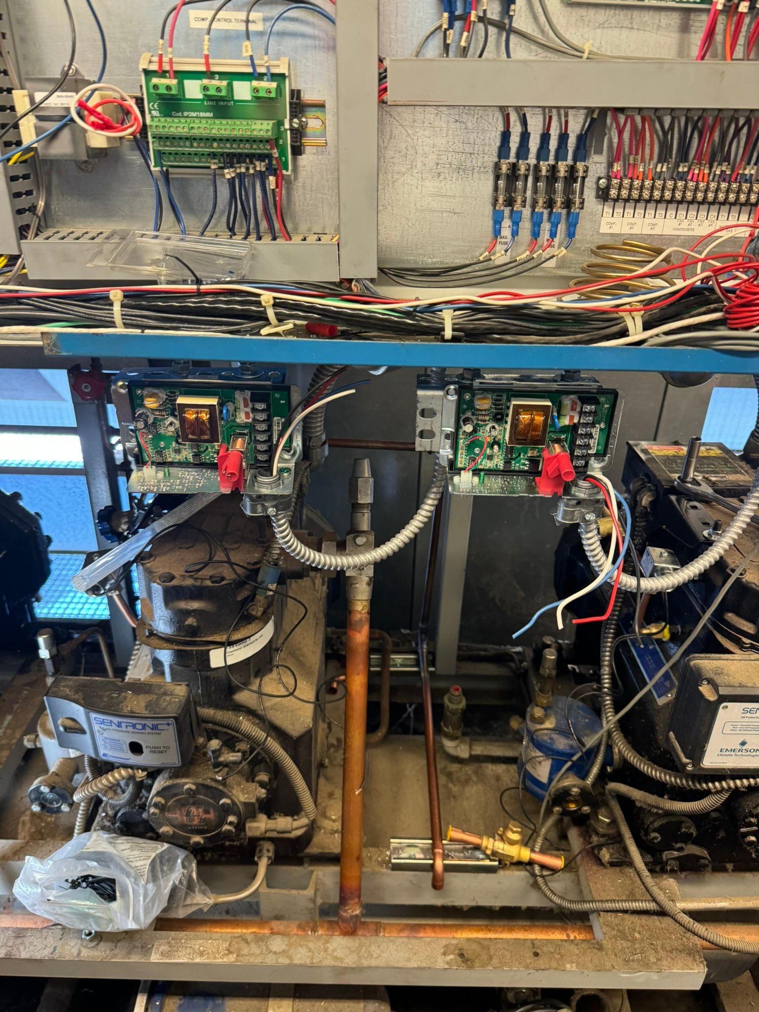 Open electrical control panel with wiring, circuit boards, and components mounted on a metal frame