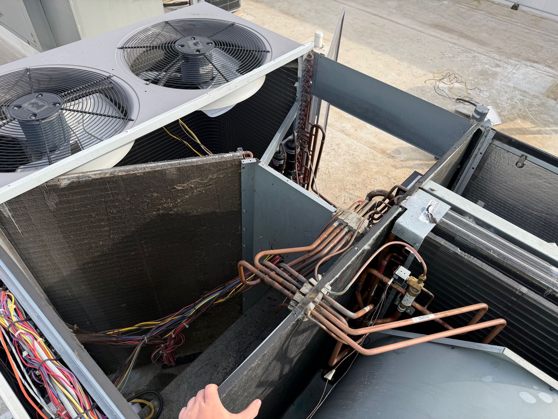 HVAC rooftop units with exposed copper pipes and wiring on a building roof