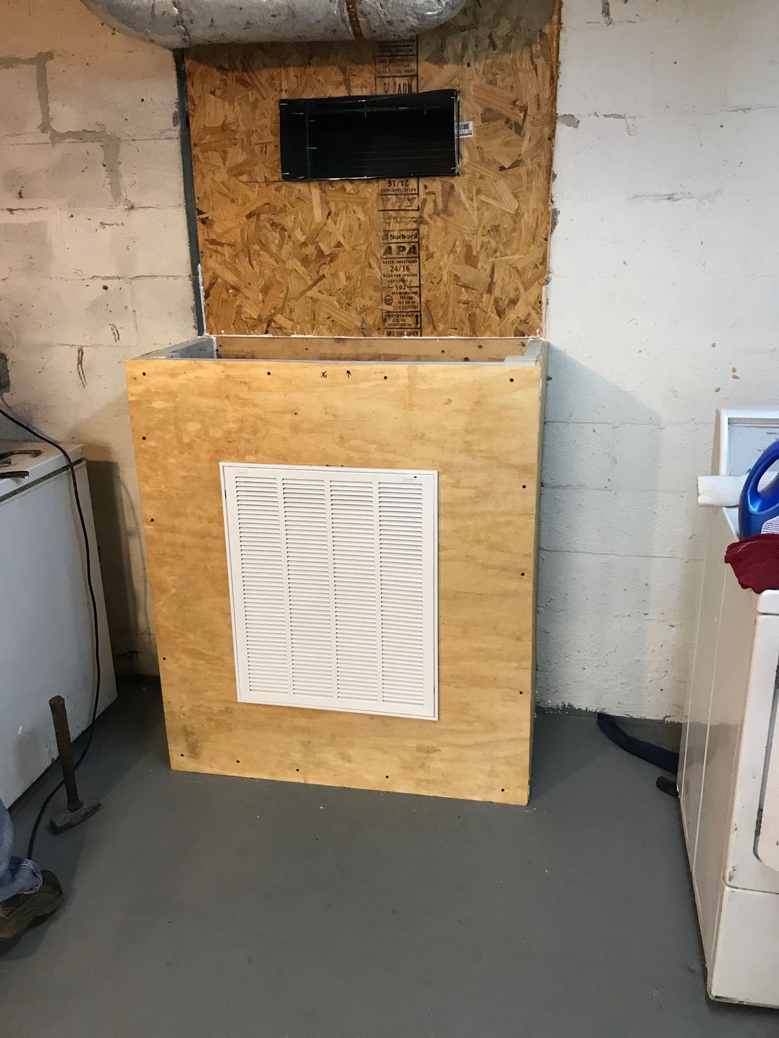Homemade plywood air filter box with vent in a basement or utility room
