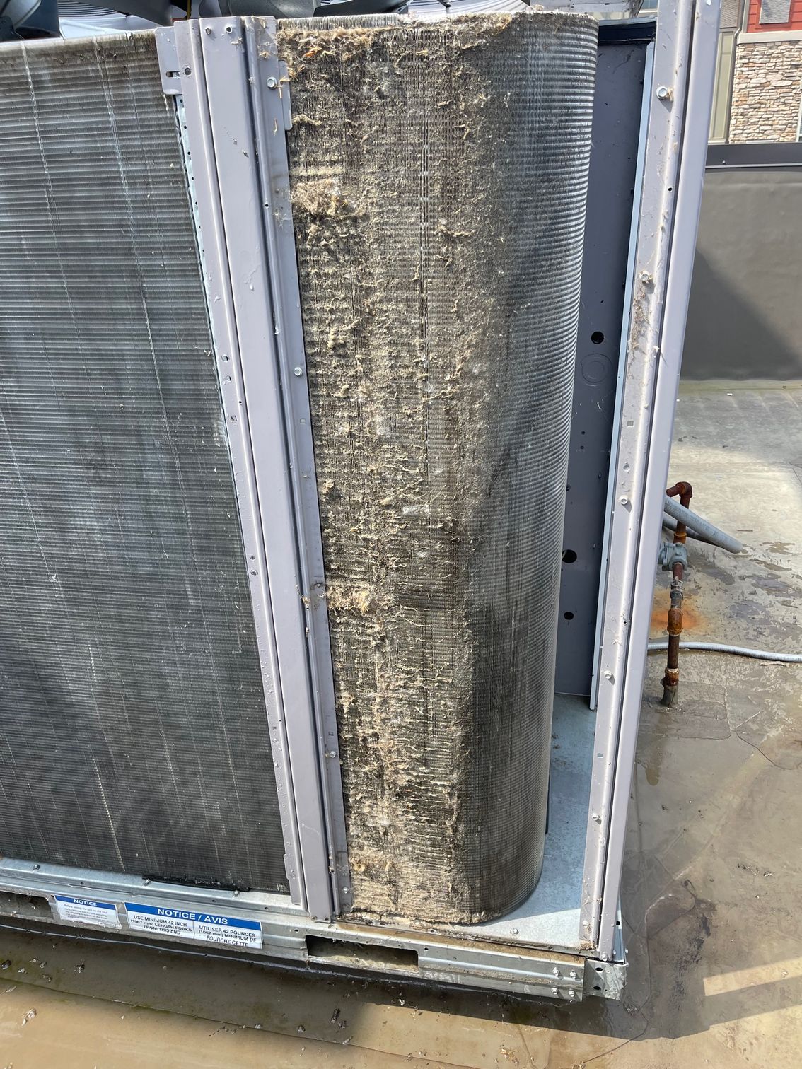 Close-up of industrial HVAC condenser coils and insulated panels on a metal frame outdoors