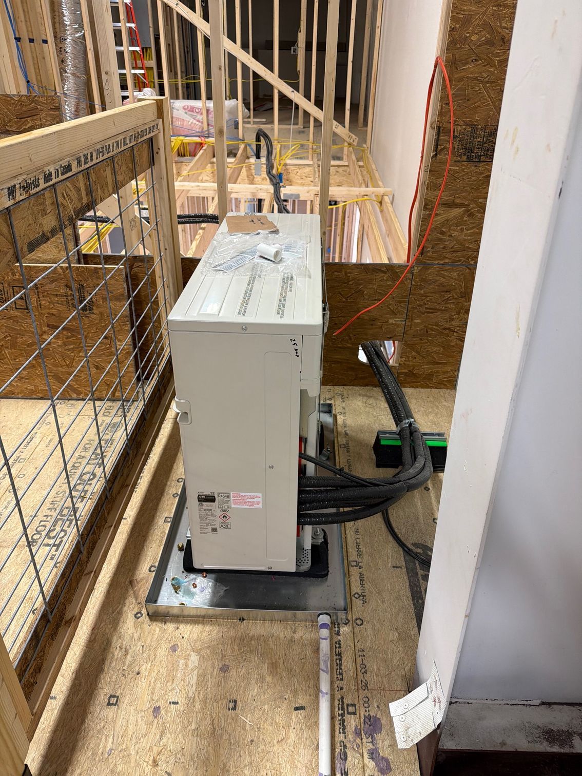 Gray electrical unit on a metal base beside a stairway, with cables and a green-handled lever.