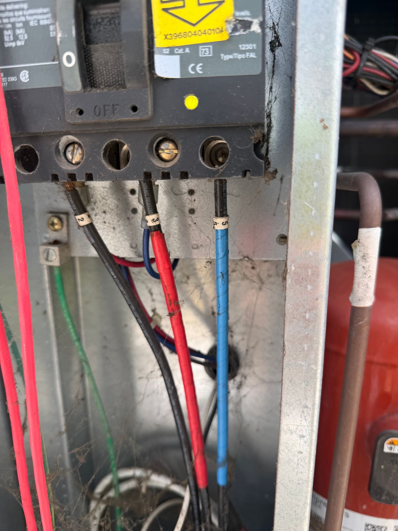 Electrical control panel with red and blue wires connected inside a metal enclosure.