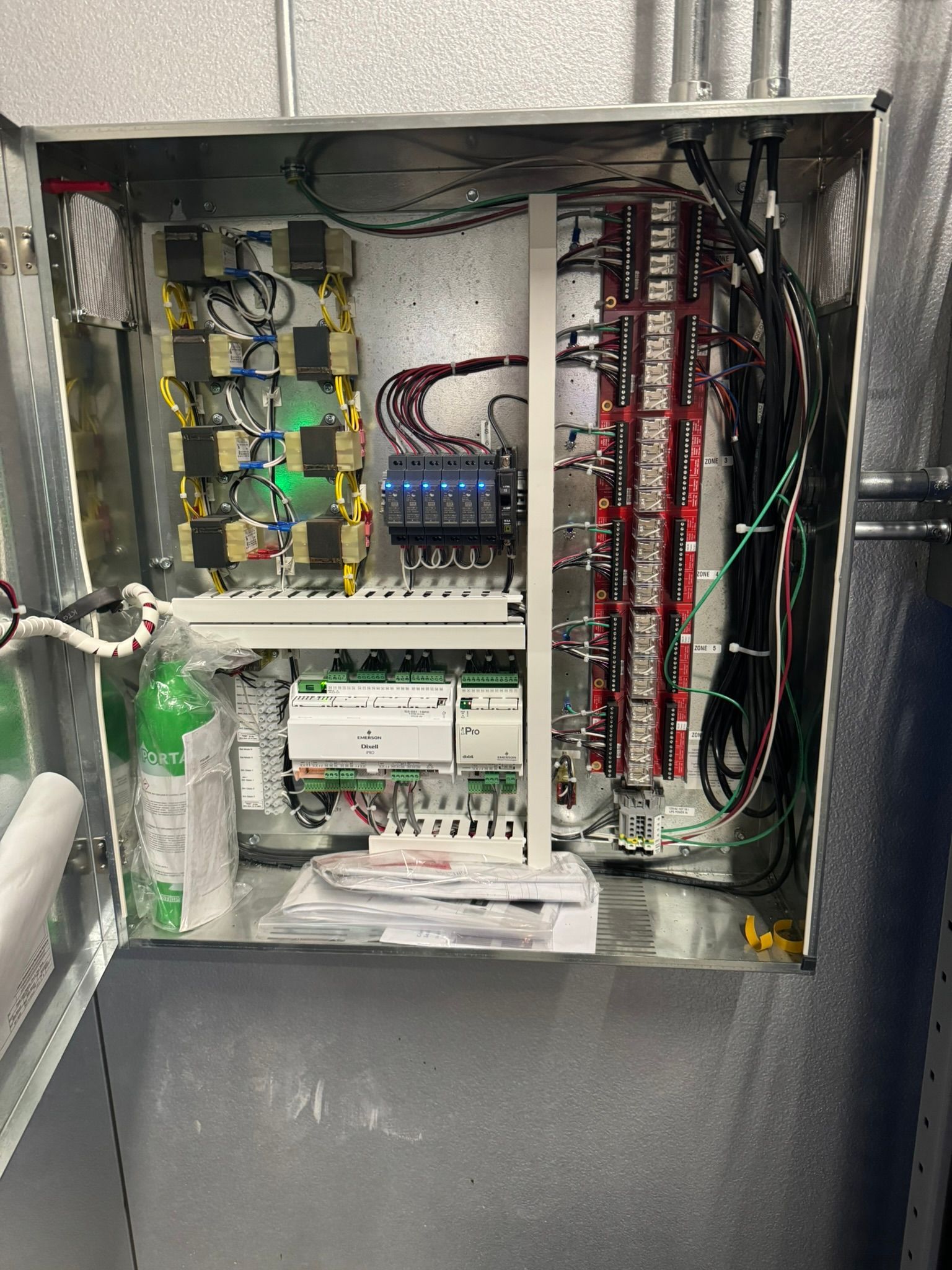 Open electrical control cabinet with circuit boards, wiring, and terminal blocks inside.