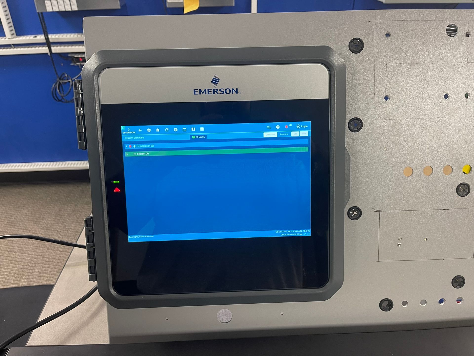 Industrial control panel with a blue touchscreen display mounted on a metal machine cabinet