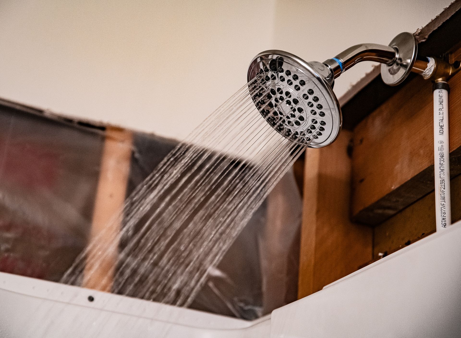 A shower head is spraying water from the ceiling in a bathroom