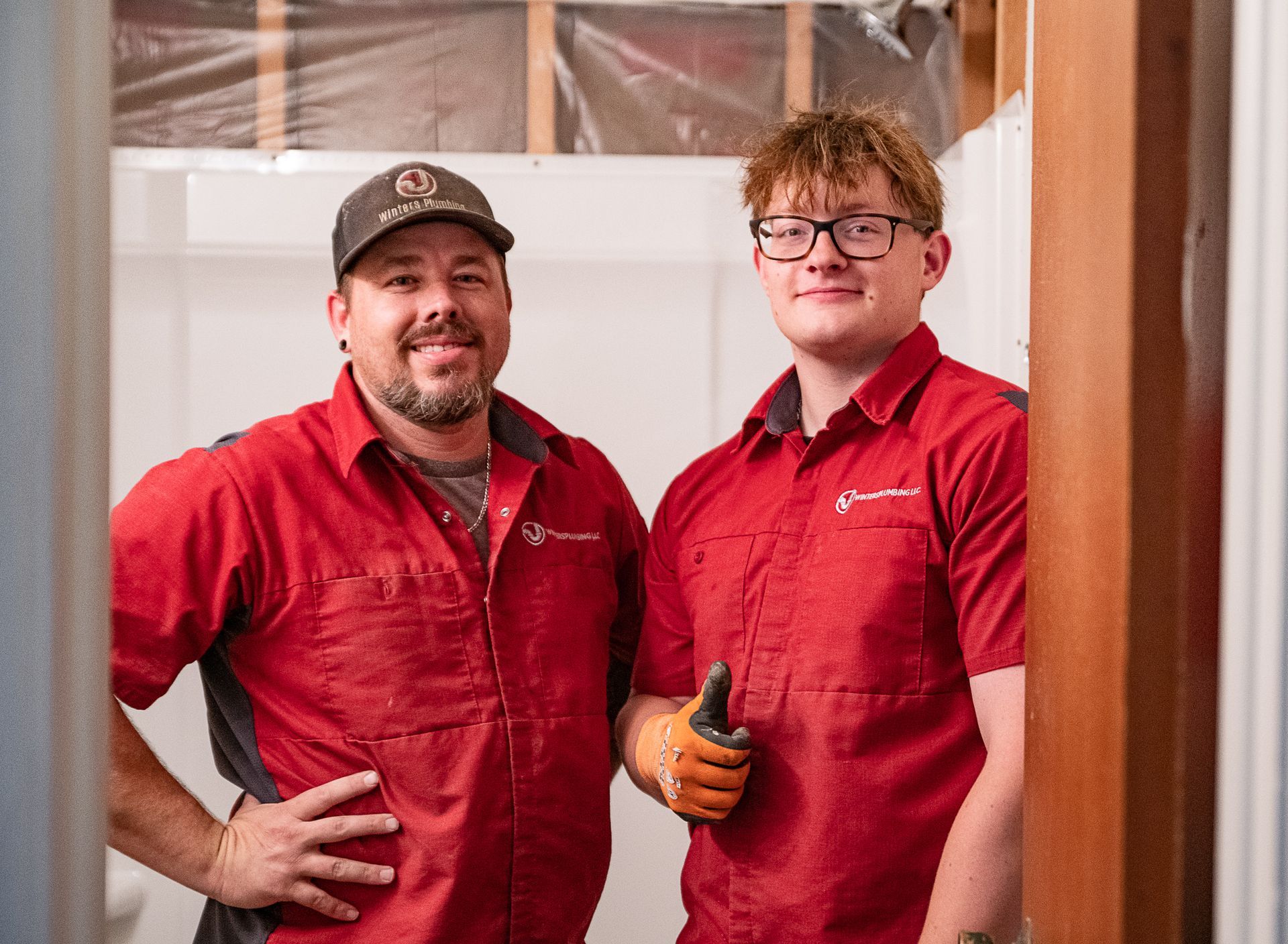 Two men in red shirts are standing next to each other in a room