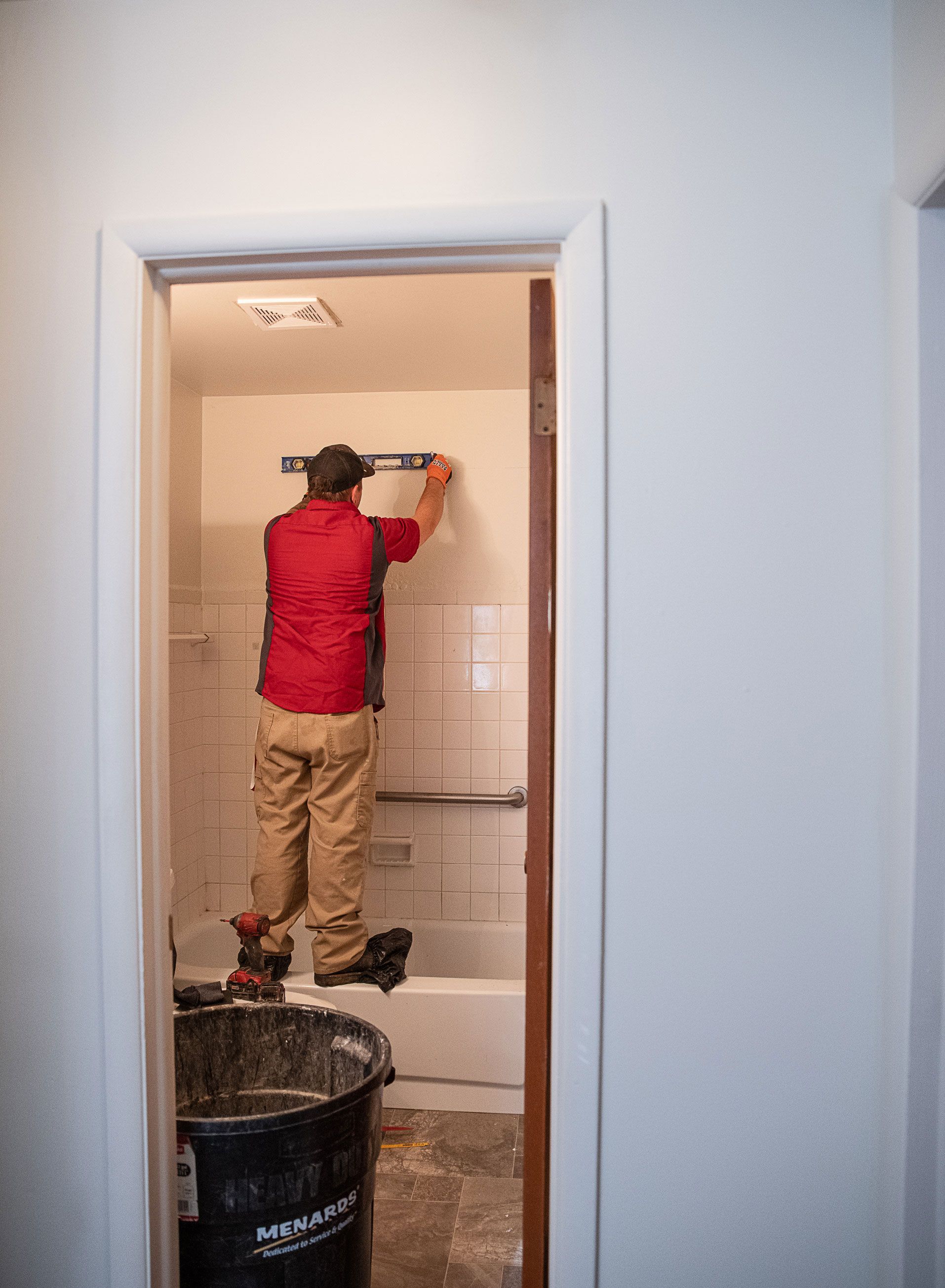 A man is working on a wall in a bathroom