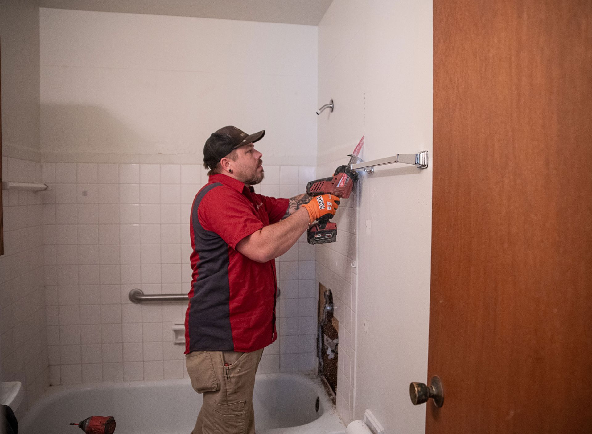 A man is working in a bathroom with a drill