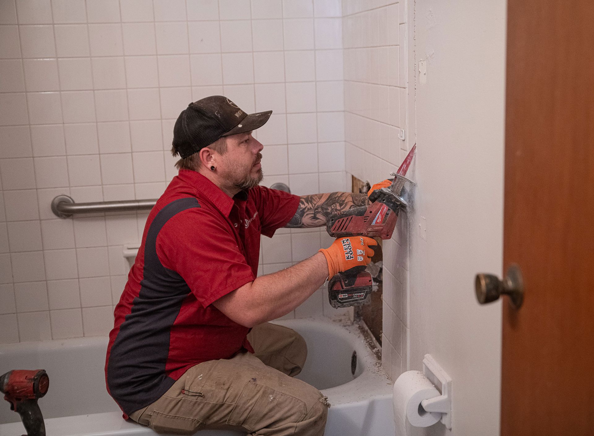 A man is working on a bathtub in a bathroom
