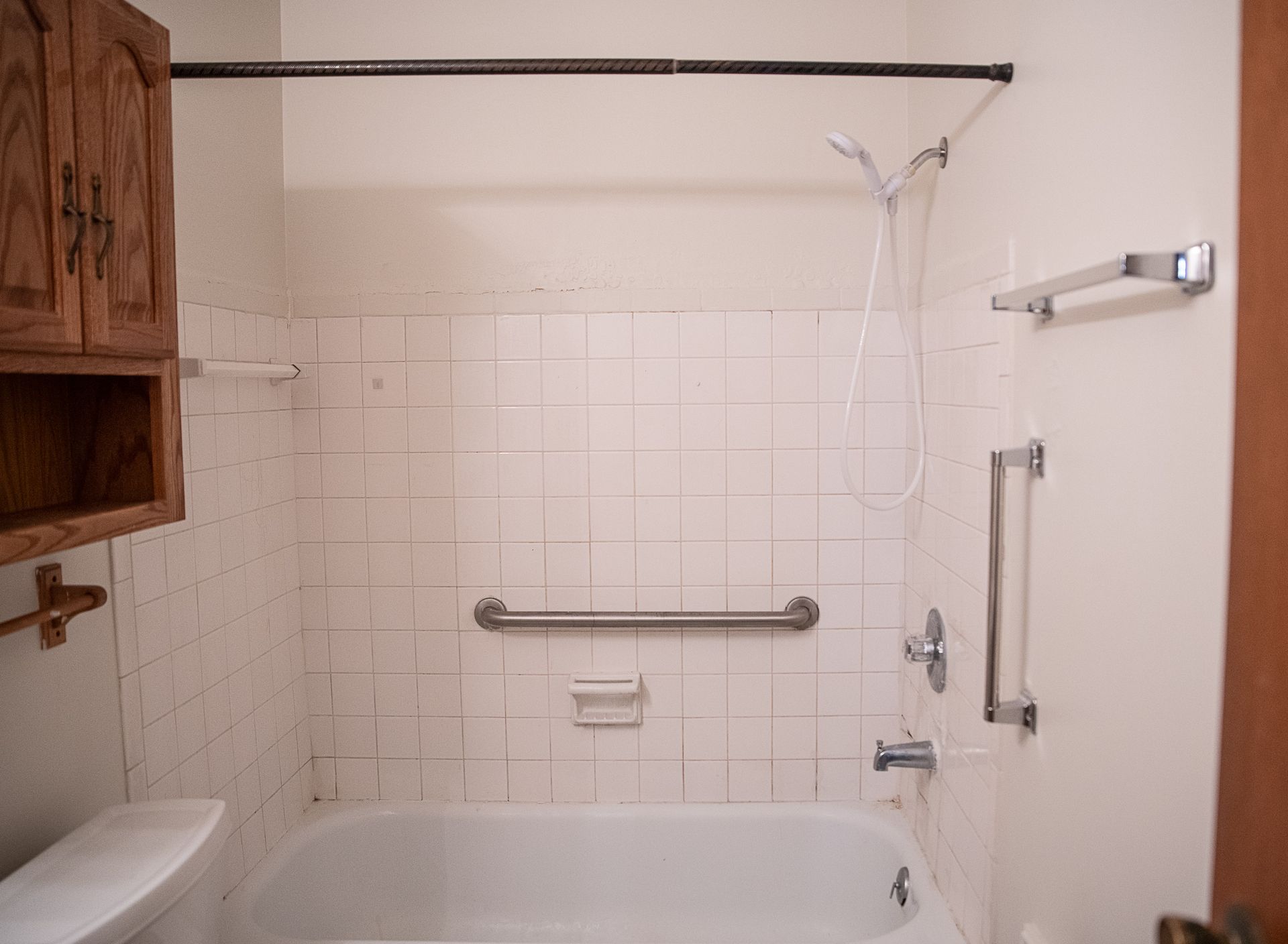 A bathroom with a tub, toilet, and shower