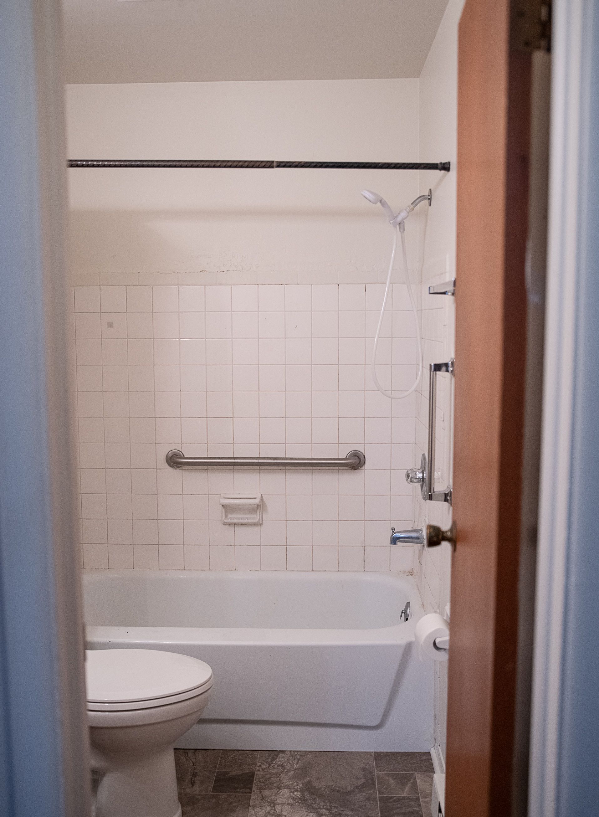 A bathroom with a toilet a tub and a shower