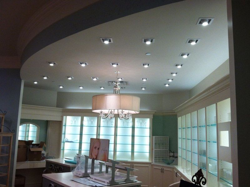Interior room with recessed ceiling lights, a large chandelier, and display cabinets.