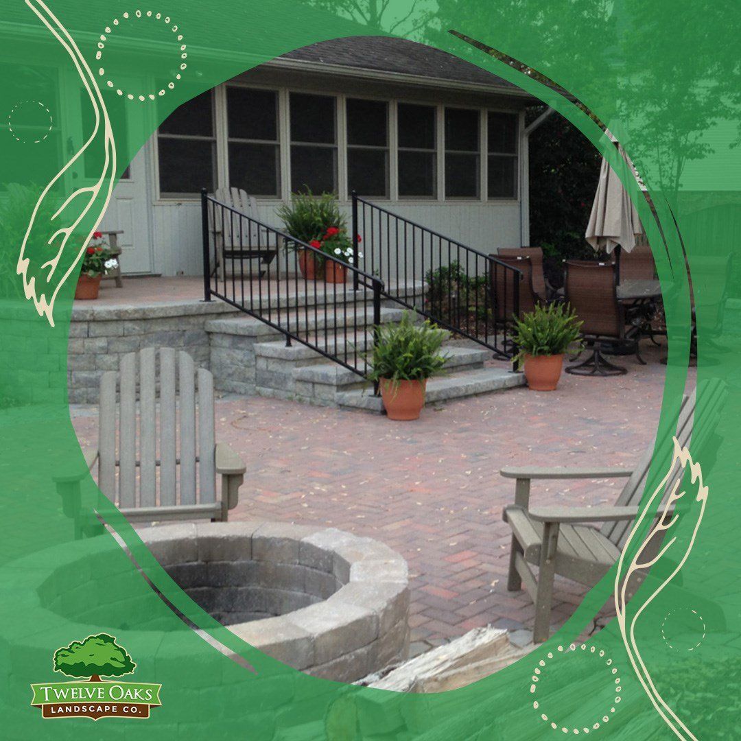 Patio with fire pit, seating, steps up to screened porch, potted plants.
