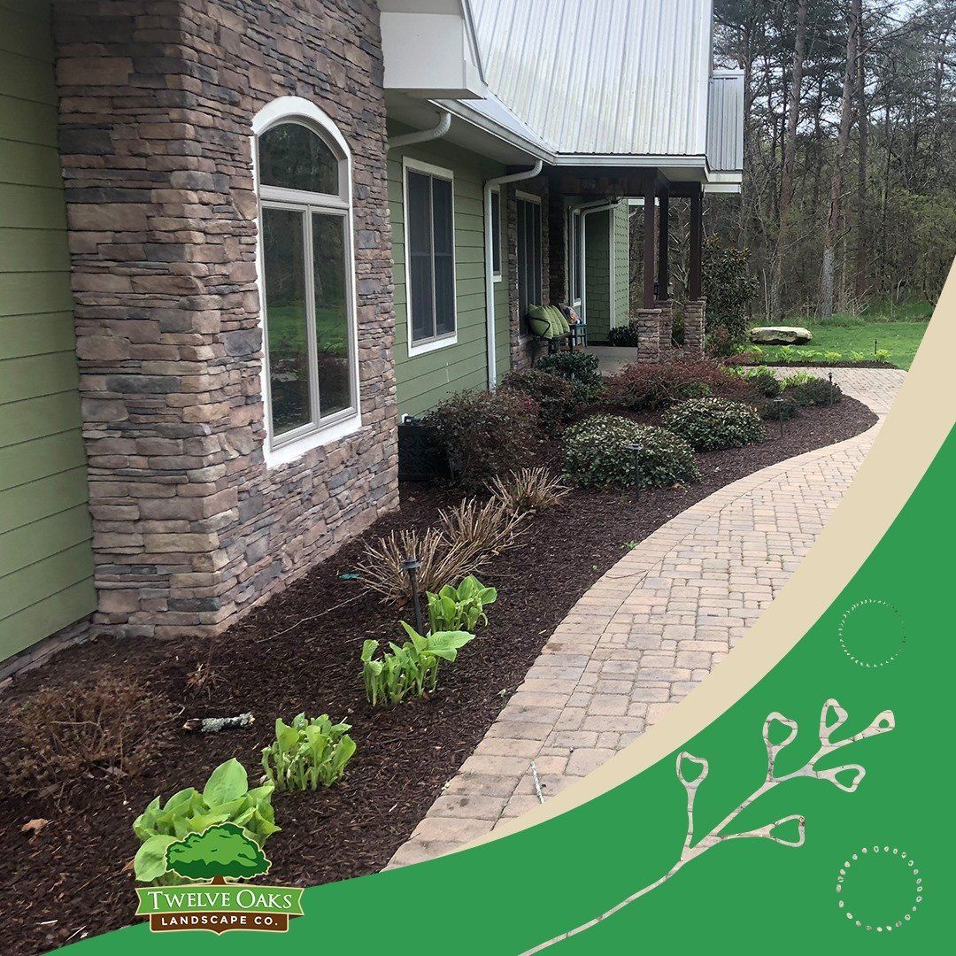 House exterior with stone facade, garden bed, and brick walkway.