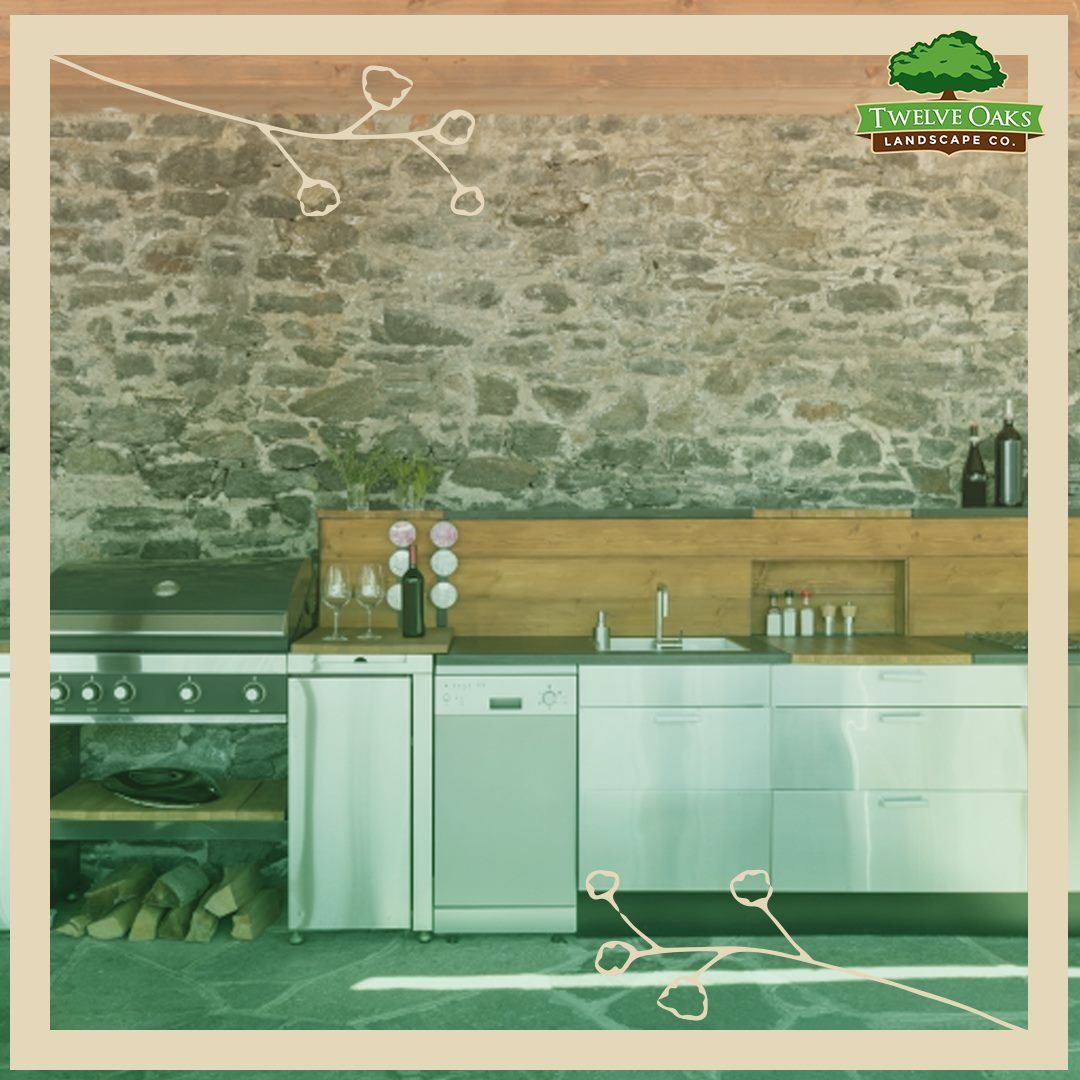 Outdoor kitchen with a stone wall, stainless steel appliances, and wooden countertops.