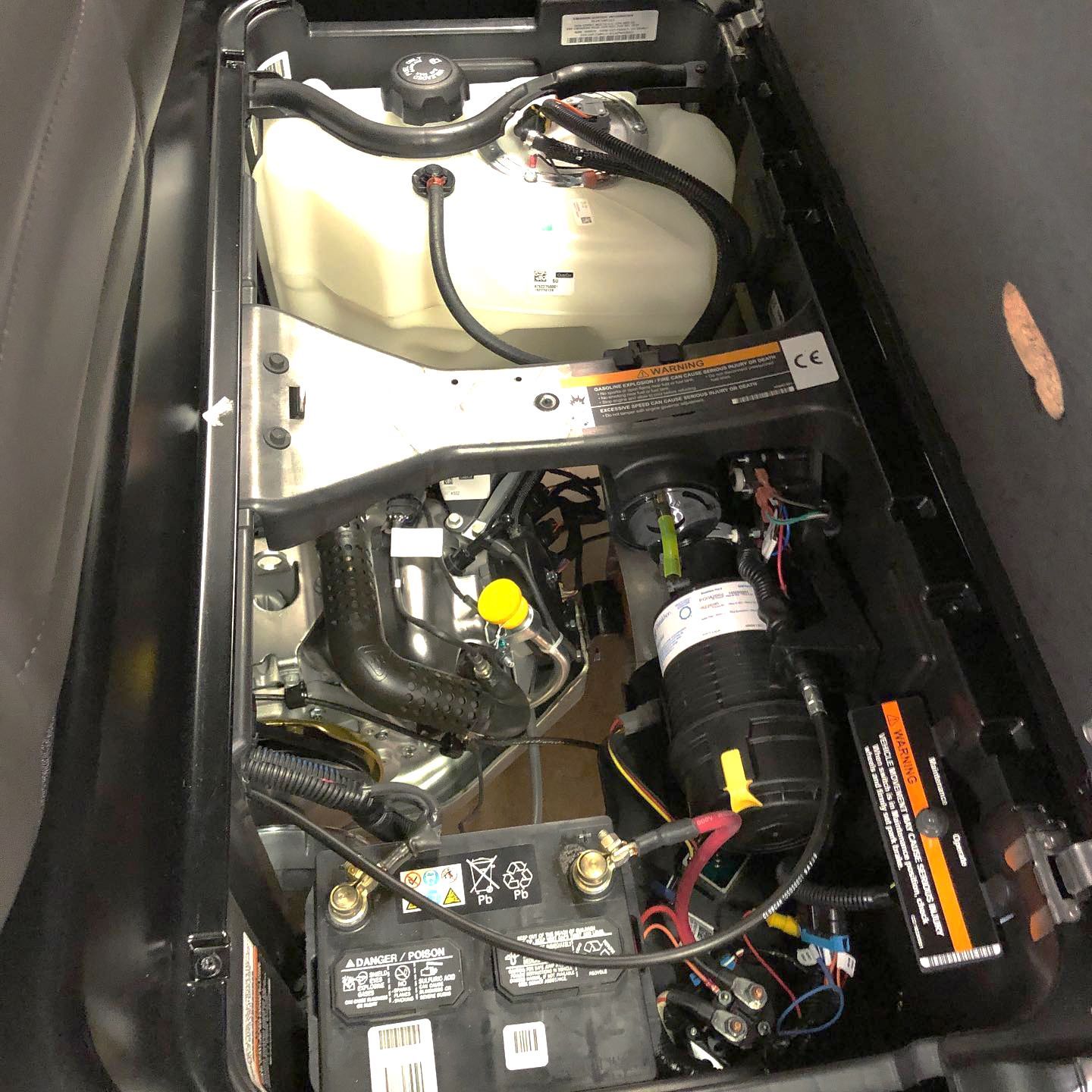 The inside of a golf cart with a battery and a water tank.