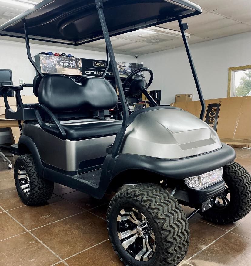 A golf cart is parked in a room in a garage.