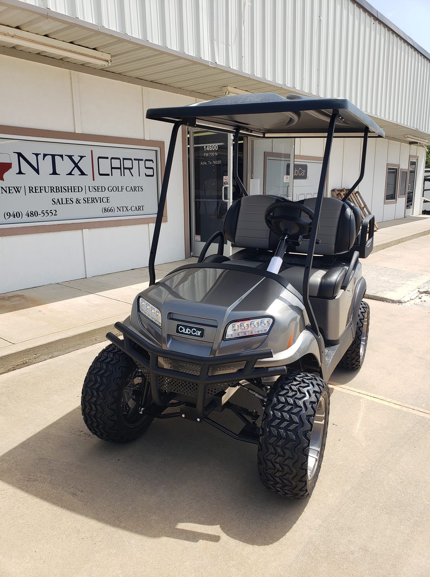 A golf cart is parked in front of a building.