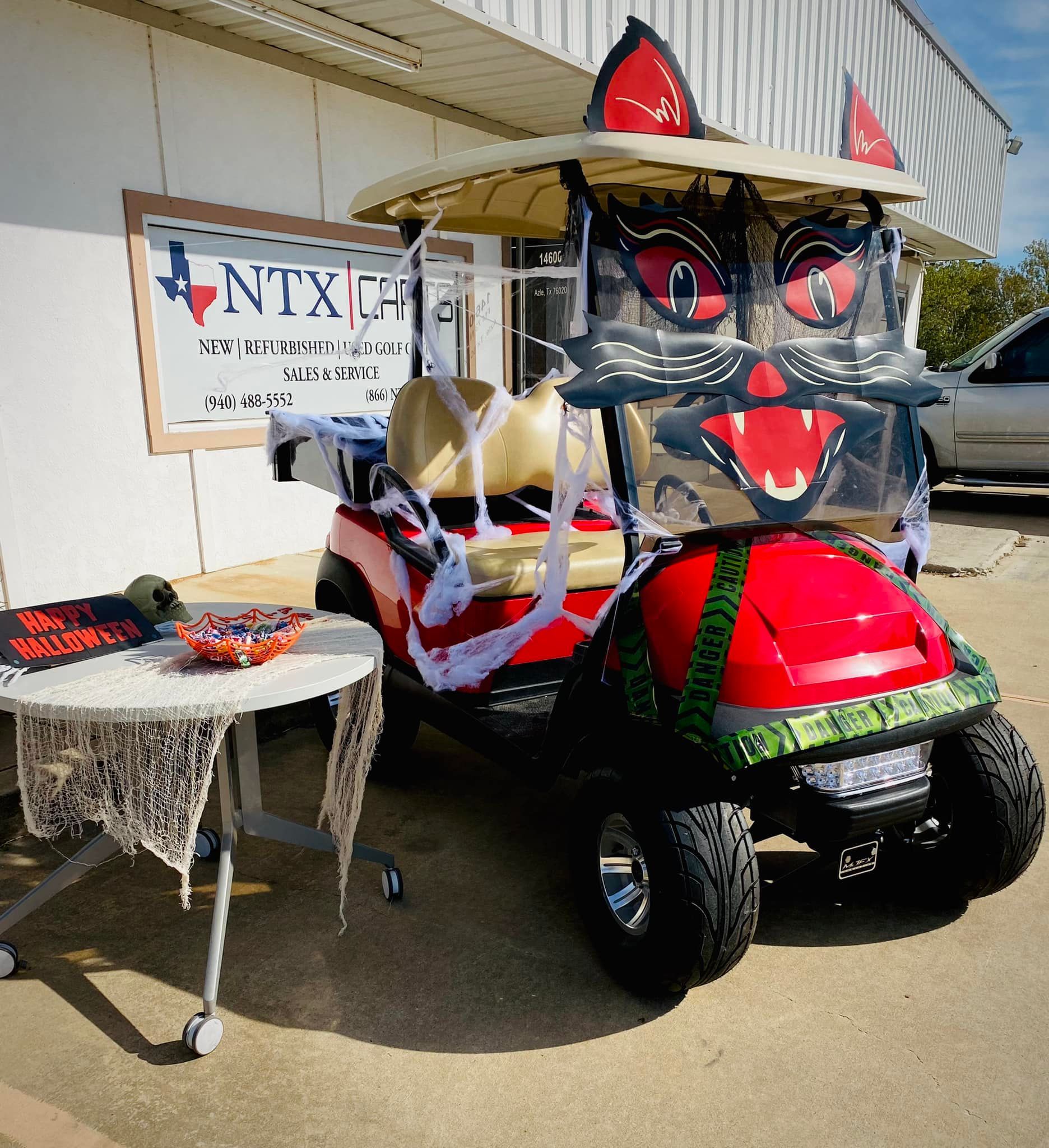A red golf cart with a cat face painted on it