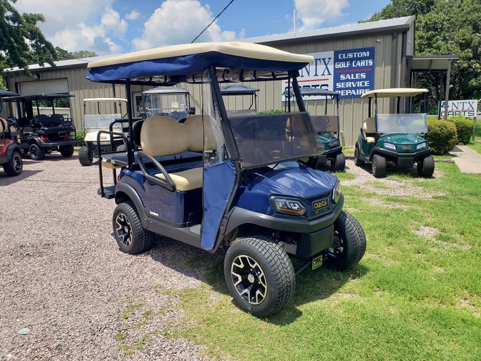 A blue golf cart is parked in front of a building.