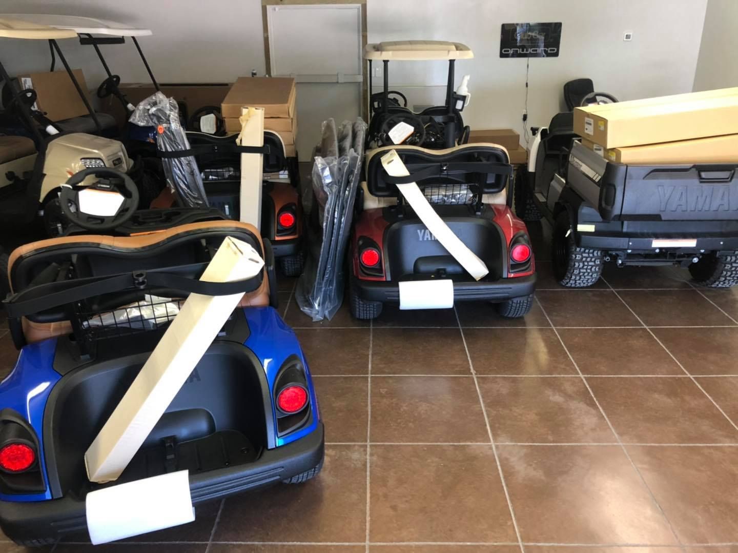 A bunch of golf carts are sitting in a room.