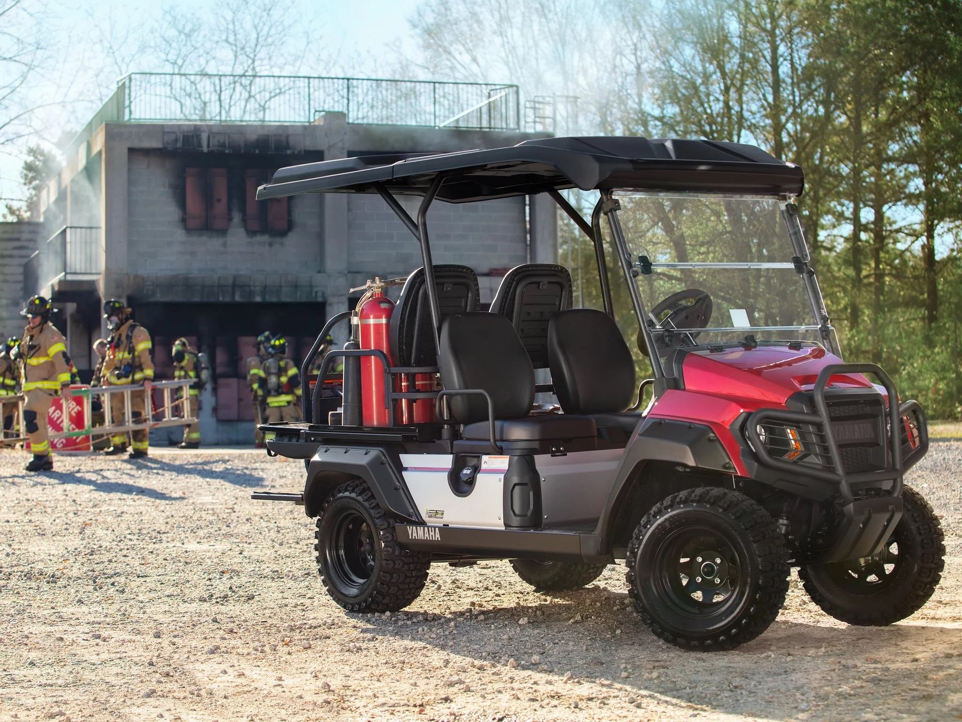 A red golf cart is parked in front of a fire station.
