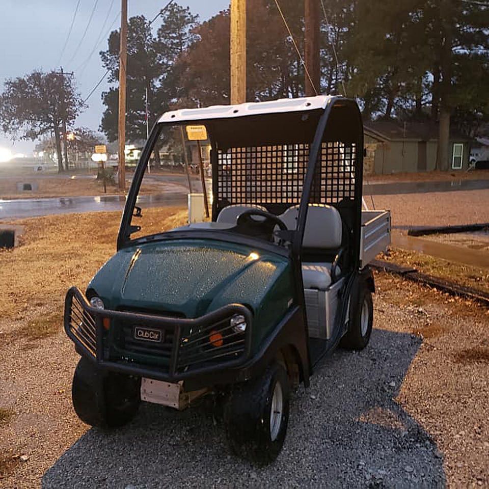 A green golf cart with the word gmc on the front