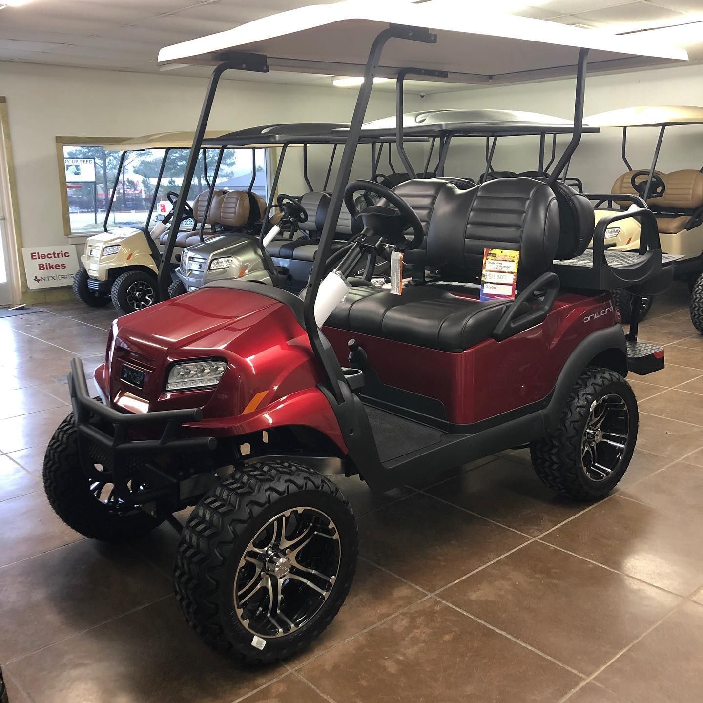 A red golf cart is parked in a showroom.