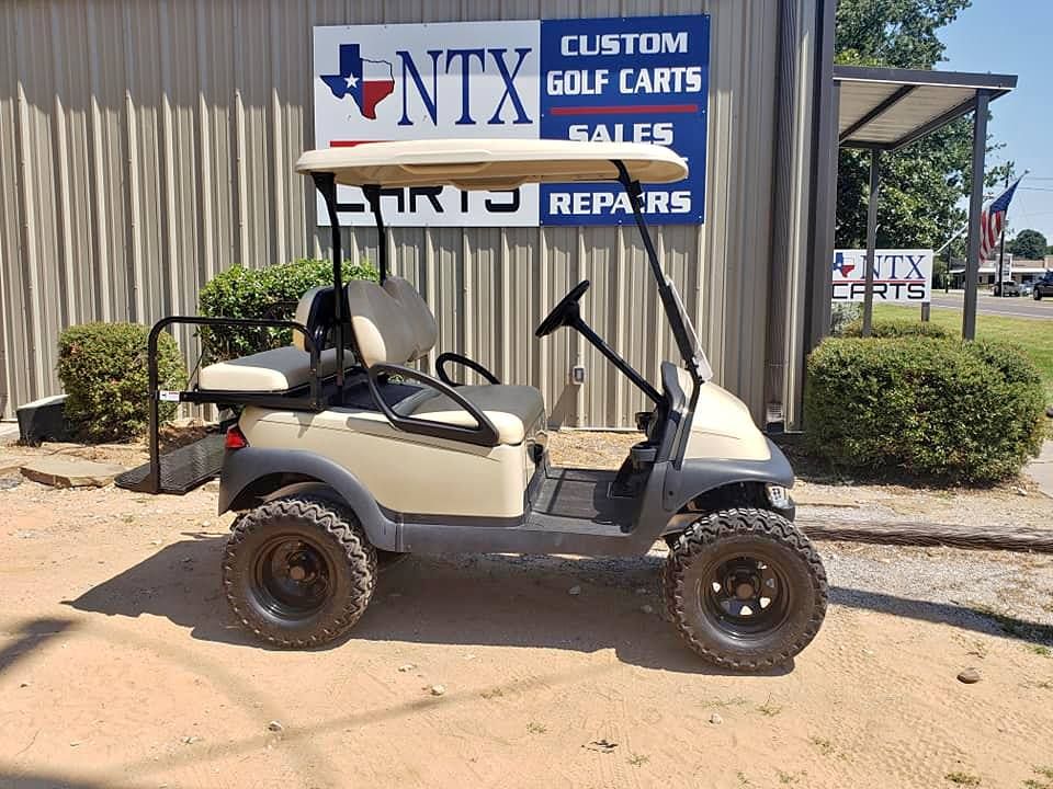 A white golf cart is parked in front of a building.