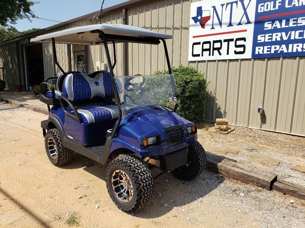 A blue golf cart is parked in front of a building.