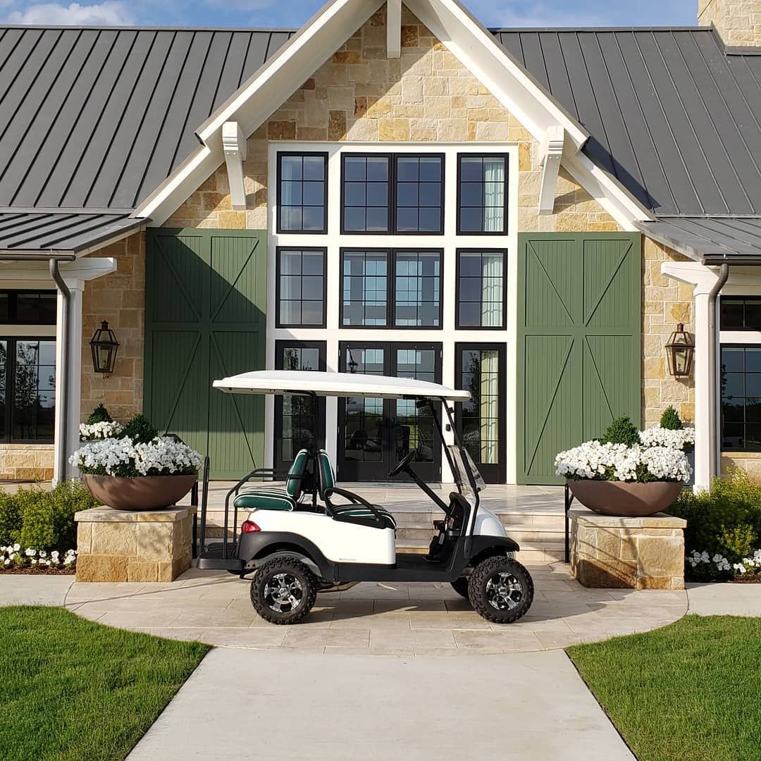 A golf cart is parked in front of a large house