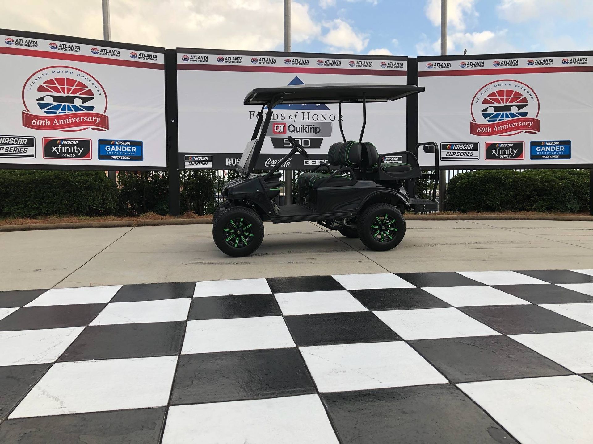 A golf cart is parked in front of a checkered floor.