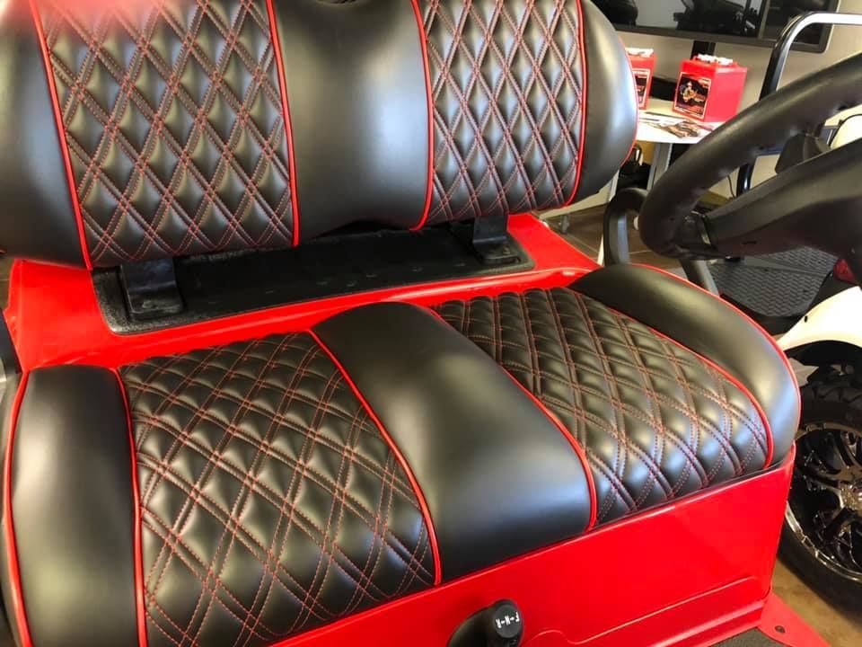 A red golf cart with black and red seats