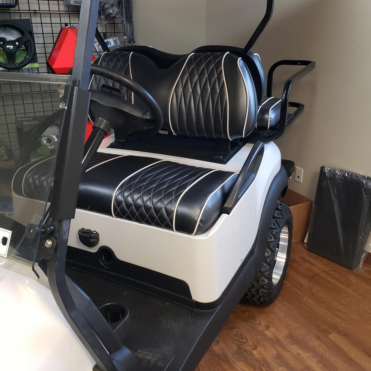 A black and white golf cart with a black seat